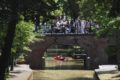 904341 Gezicht op de Brigittenbrug over de Nieuwegracht te Utrecht, met op de brug een groep toeristen die een ...